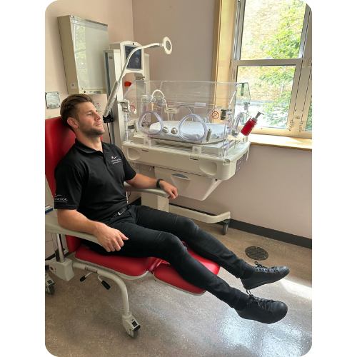 Man sat in Kangaroo Recliner chair next to incubator with footrest up. Man sat in Kangaroo Recliner chair next to incubator with footrest up.