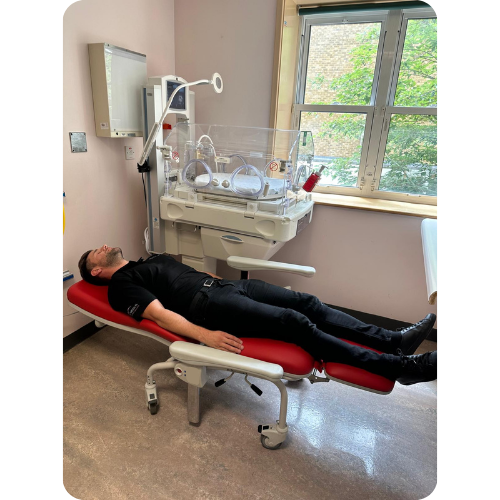 Man laying in Kangaroo Recliner chair next to incubator in fully reclined position. Man laying in Kangaroo Recliner chair next to incubator in fully reclined position.
