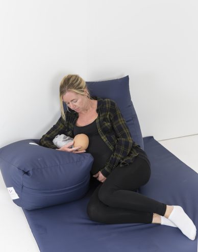 Mother breastfeeding on pregnancy wedge pillow